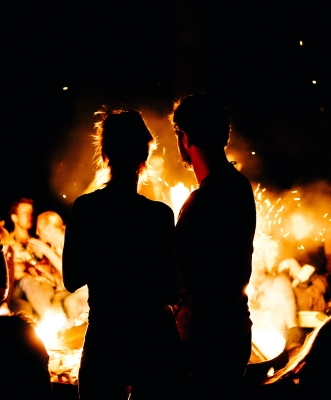 para patrzy na ognisko, które symbolizuje namiętność w ich związku