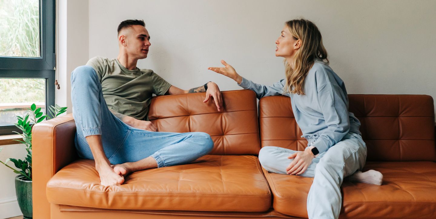 Jak przestać się kłócić o obowiązki domowe - czy kompromis działa? - kobieta i mężczyzna siedzą na kanapie i rozmawiają o obowiązkach domowych - Marita Woźny